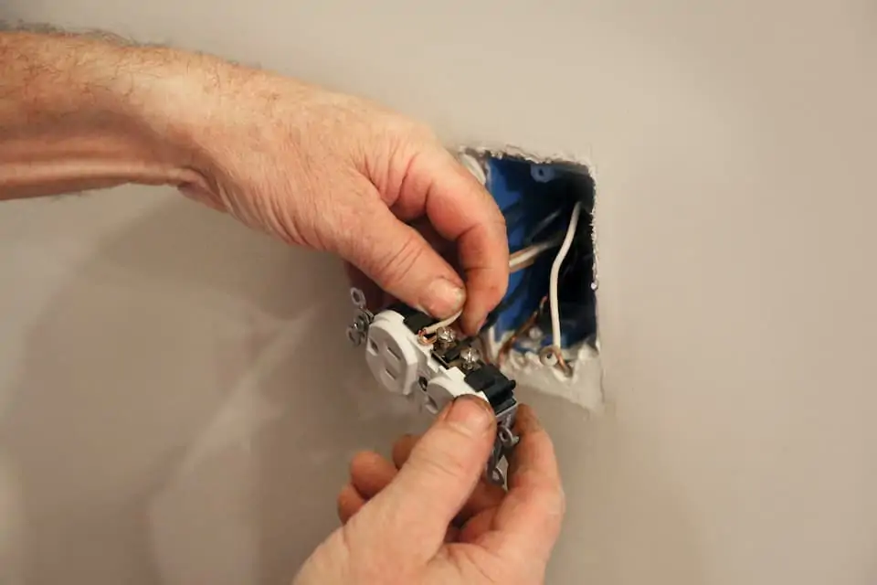 Man replacing electrical wall outlet; how to add an electrical outlet