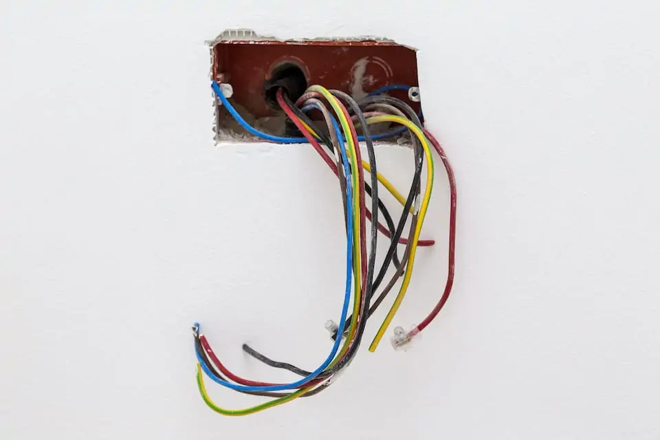 Unfinished electrical mains outlet socket with electrical wires - connector installed in the wall in apartment; how to add an electrical outlet