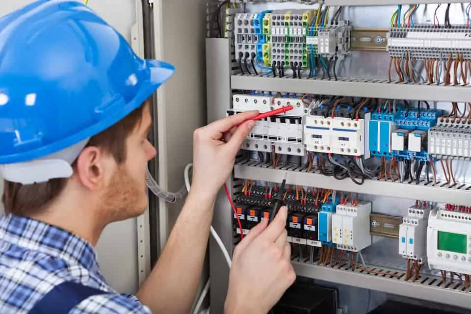 Technician Examining Fusebox With Multimeter Probe; how to become an electrician