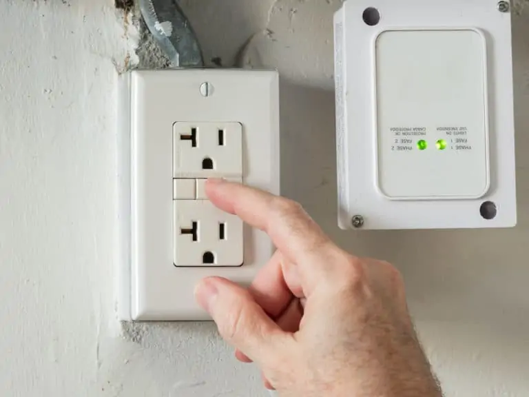 Closeup of hand resetting tripped GFI electricity outlet. Residential gfci ground fault interrupter electric socket plug and wall plate: outdoor outlet not working