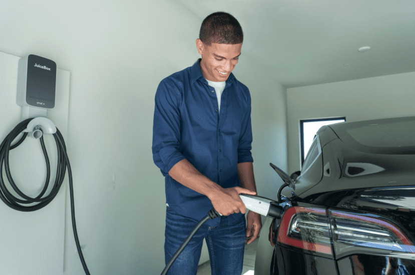 man in garage at home plugging in his juicebox electric car charging station