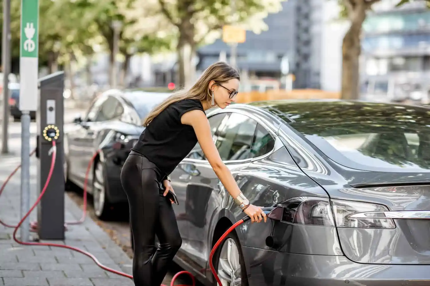woman charging EV on-board charger electric vehicle