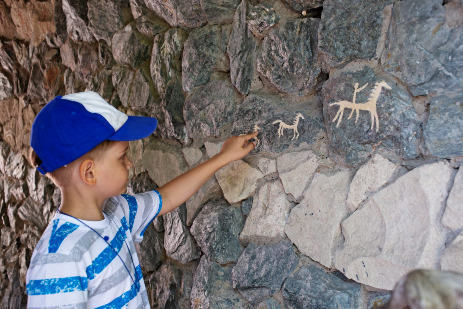 Ancient cave paintings and little boy. Bronze Age culture dated; history of st. paul
