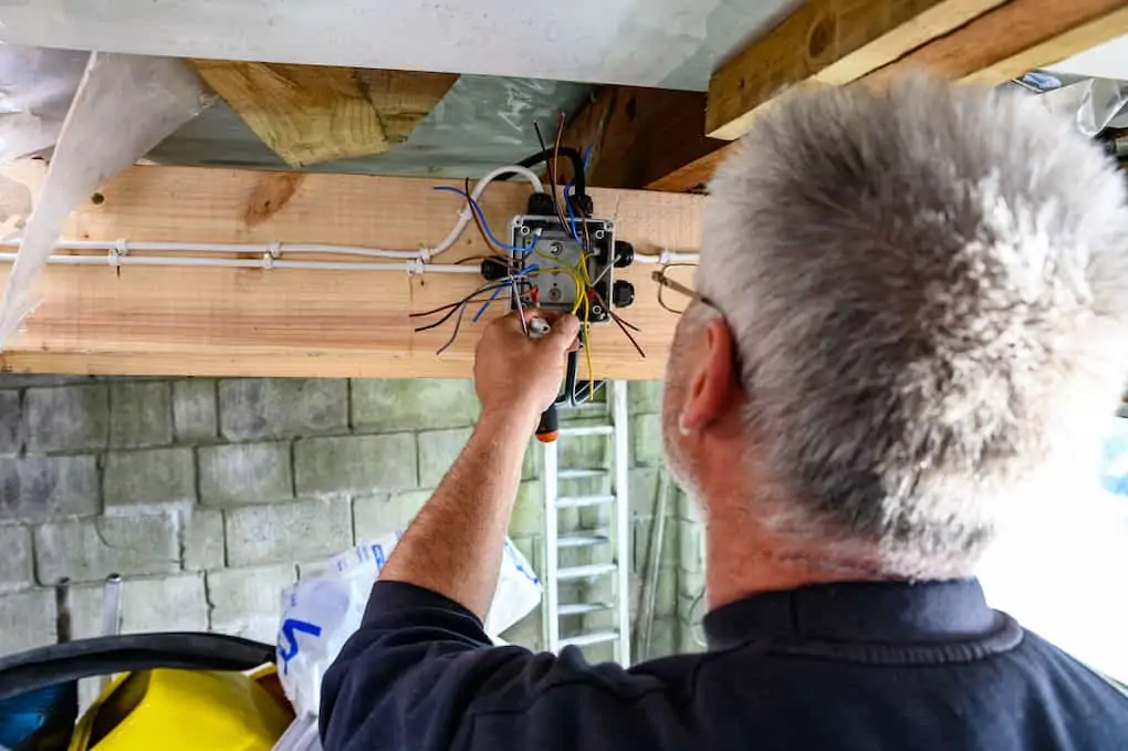 Male wiring a junction box at home after learning how to wire a garage