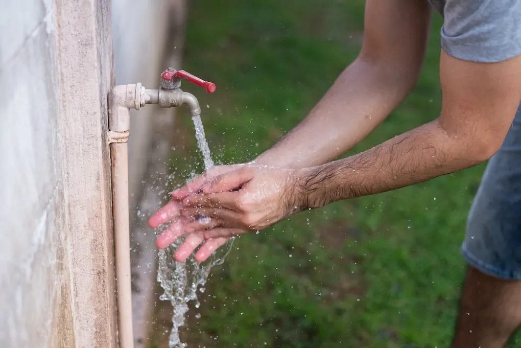 close up of a man washing hands; types of outdoor faucets
