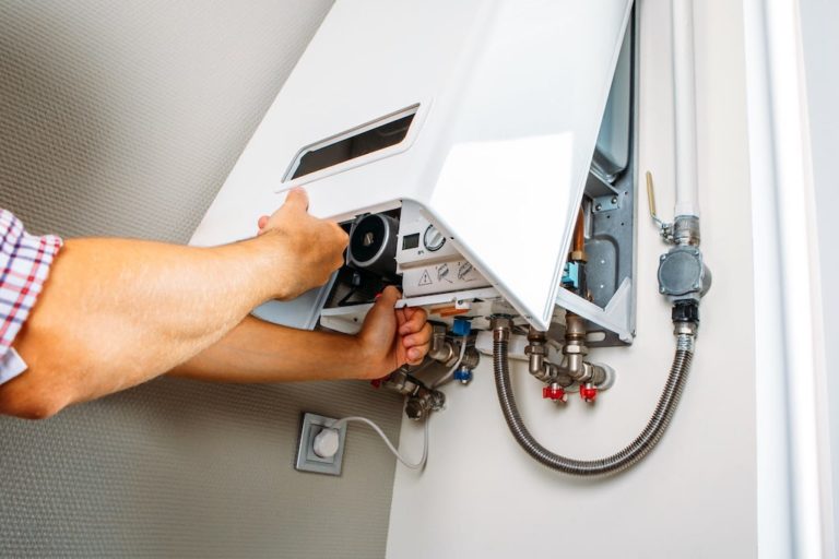 man installing water heater panel; tankless water heater vs tank