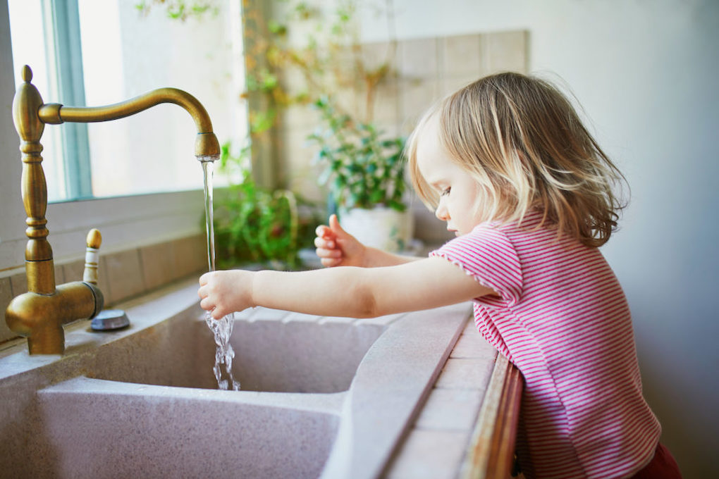 small toddler washes her hands in a double basin sink; types of kitchen sinks