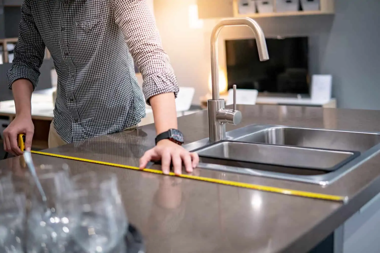 A technician measuring the width of a kitchen countertop