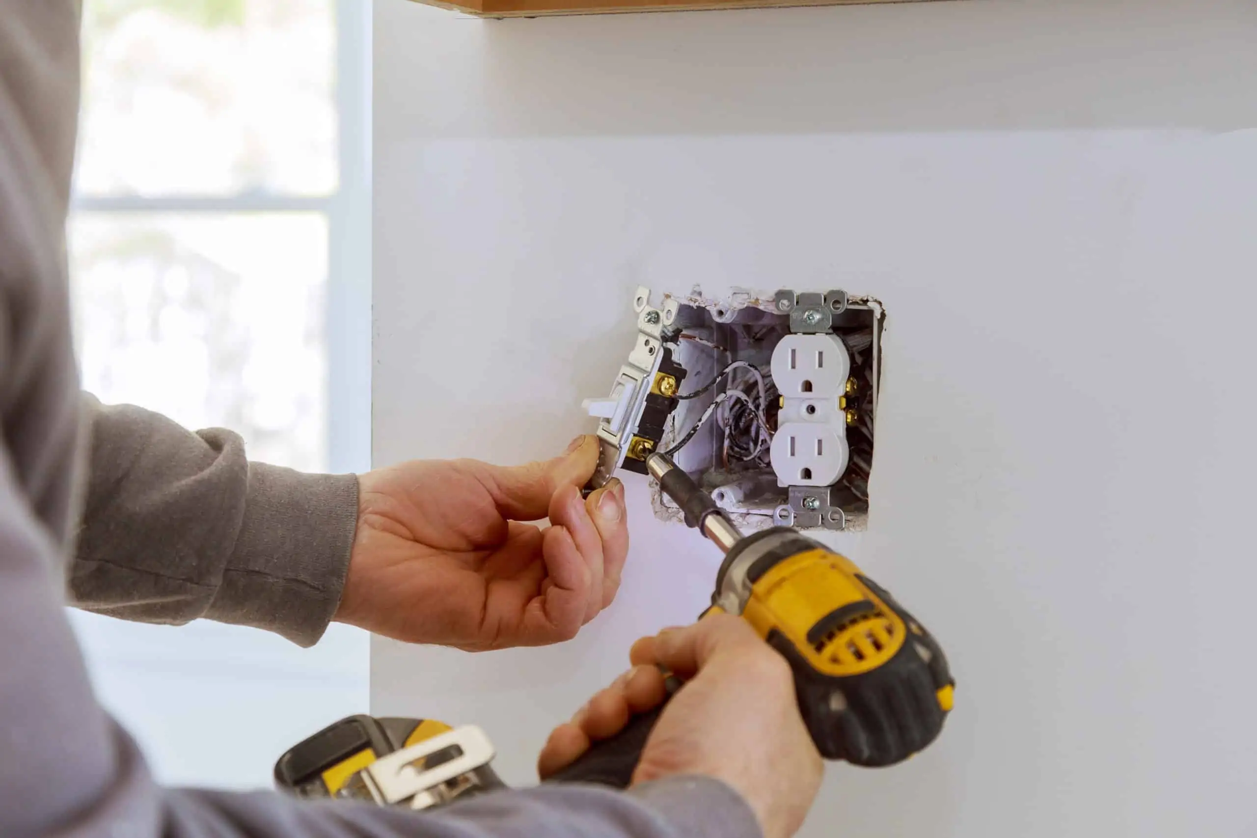 man working on diy outlet installation in his home