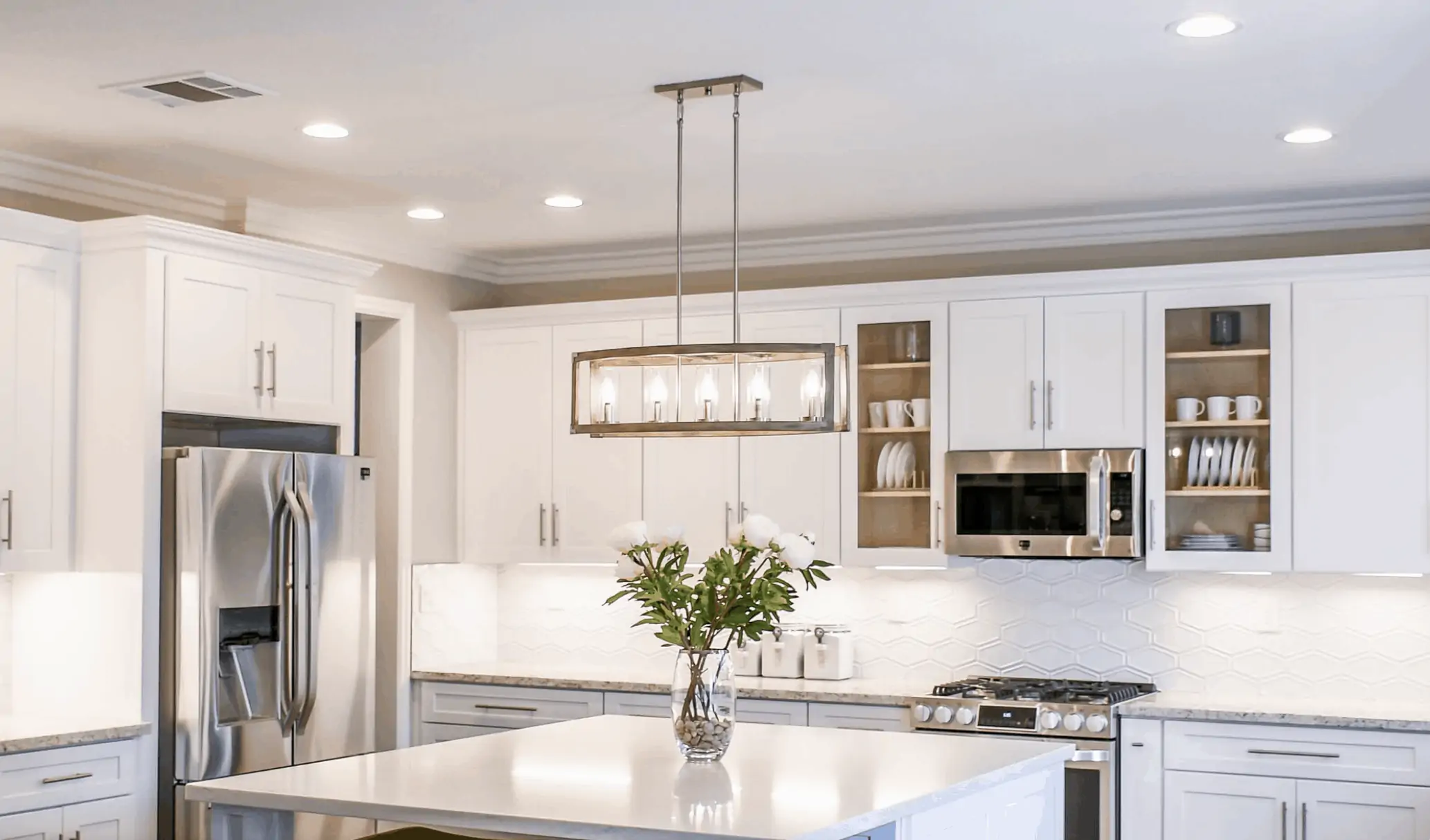 A sleek kitchen with multiple overhead light fixtures