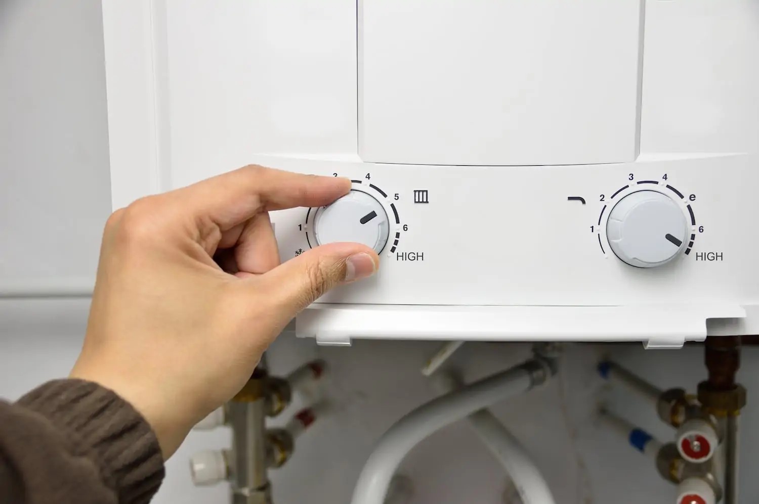Person adjusting setting on tankless water heater
