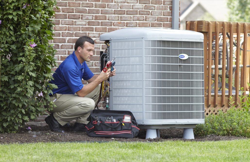 HVAC technician checking AC unit gauge