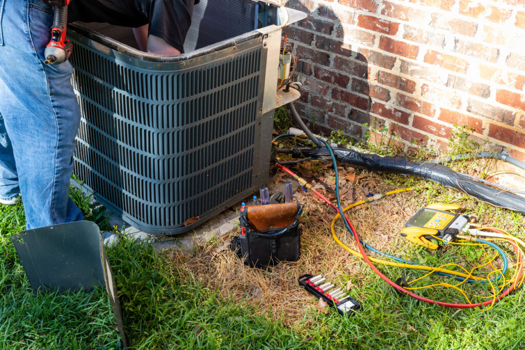 HVAC tech servicing an AC unit