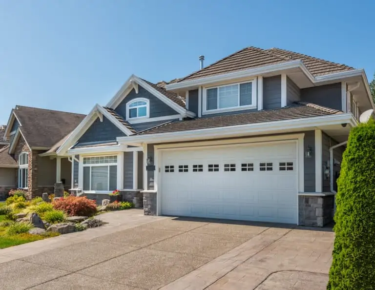 A gray-colored two-story house in Plymouth with a garage and an empty driveway.