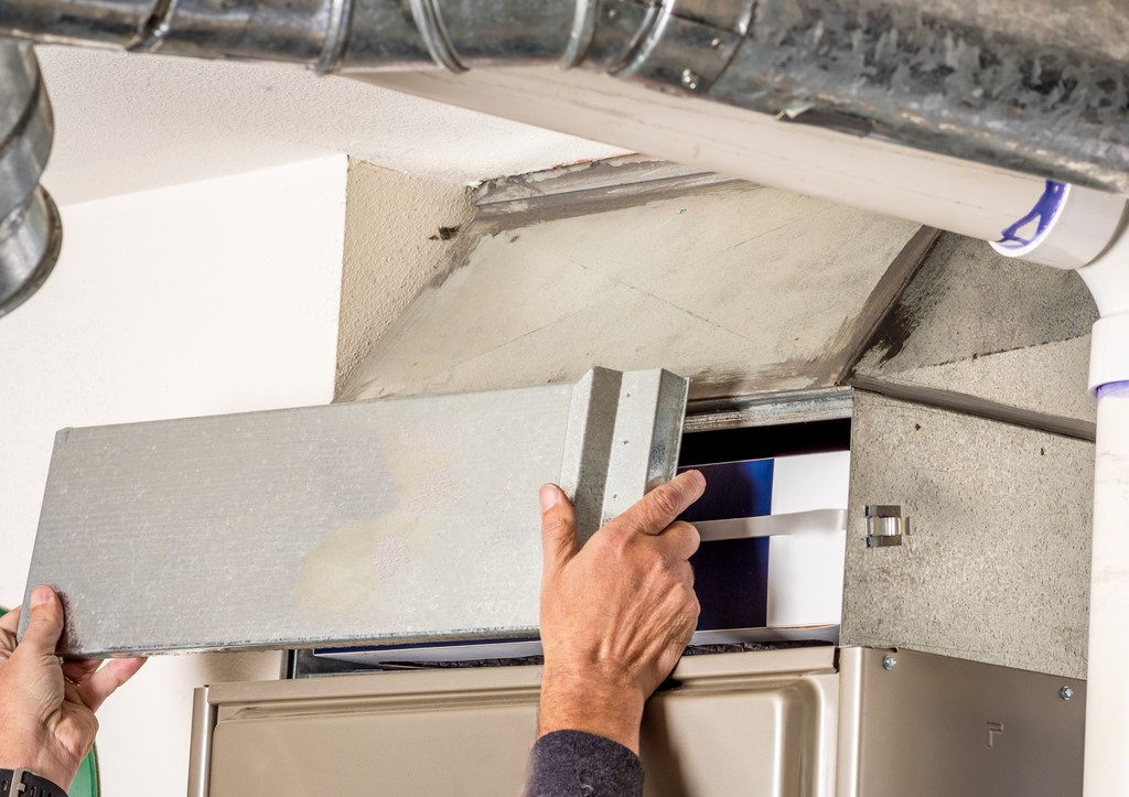 HVAC technician removing furnace access panel