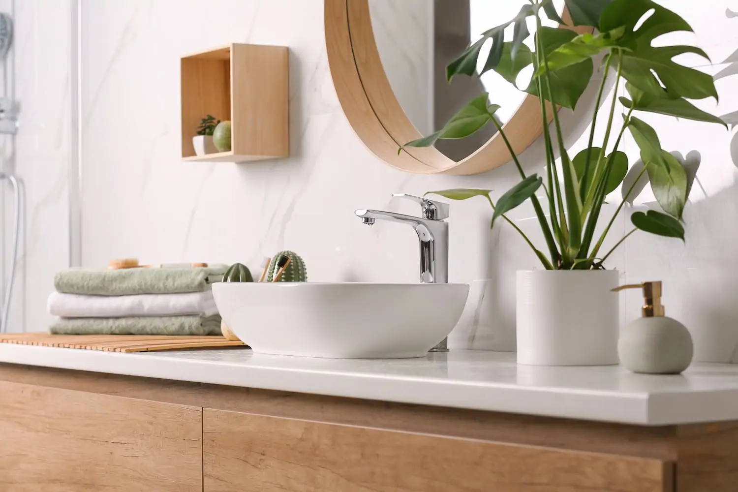 Modern bathroom remodel featuring a sink bowl and wood cabinets with a white, green, and wood detailing theme