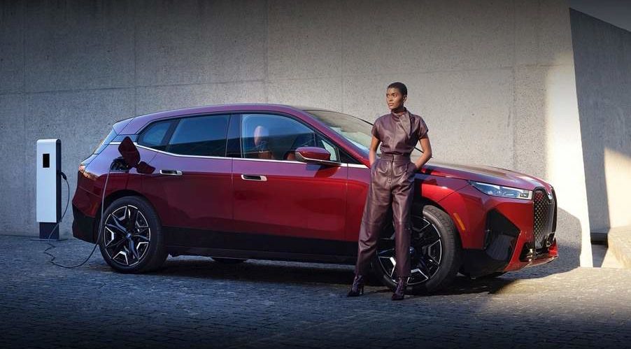 BMW iX red car with woman standing in front; extended range electric vehicles