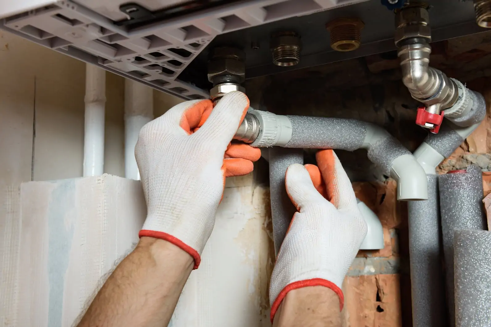 boiler installationThe worker is connecting the pipes to a domestic gas boiler.