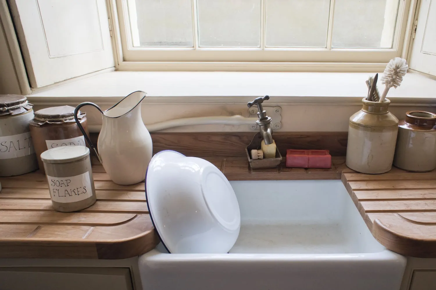 enamel kitchen sink with dishes in it