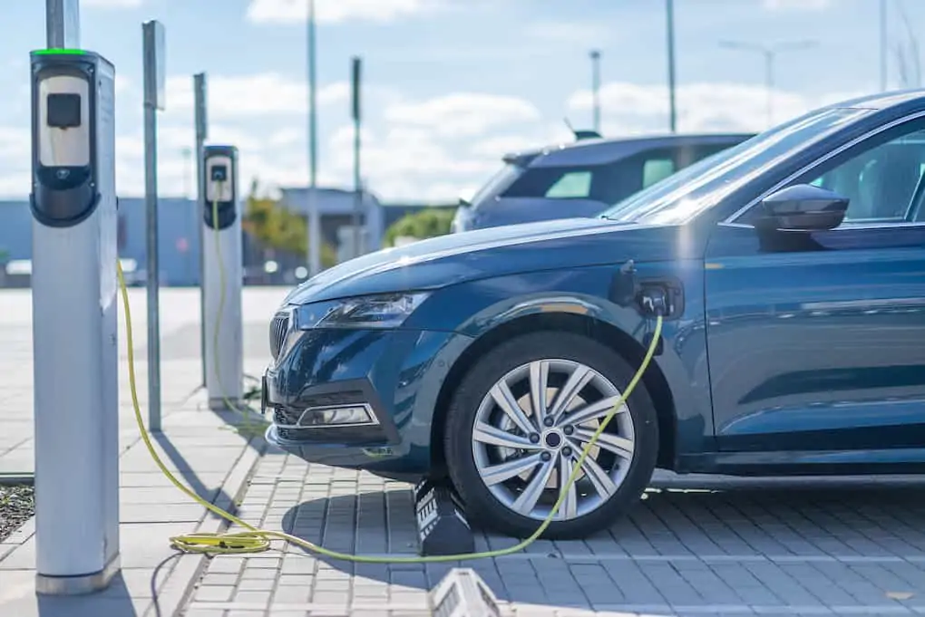 rows of cars at dealership ev charging station