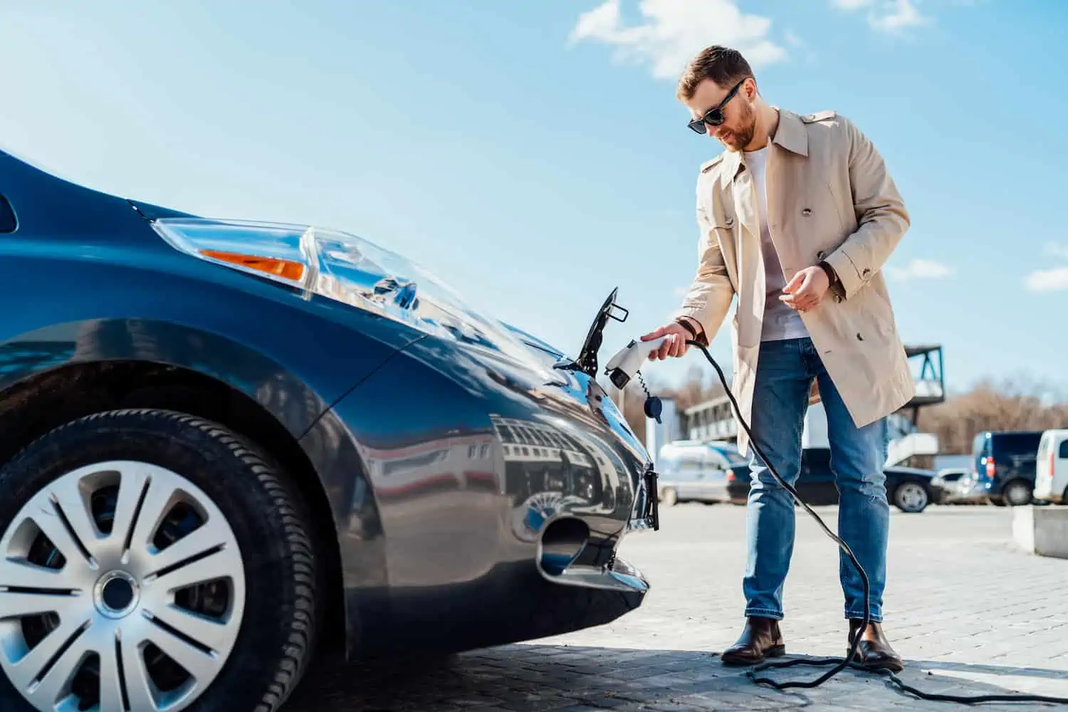 man charging his electric vehicle outdoors; EV on-board charger