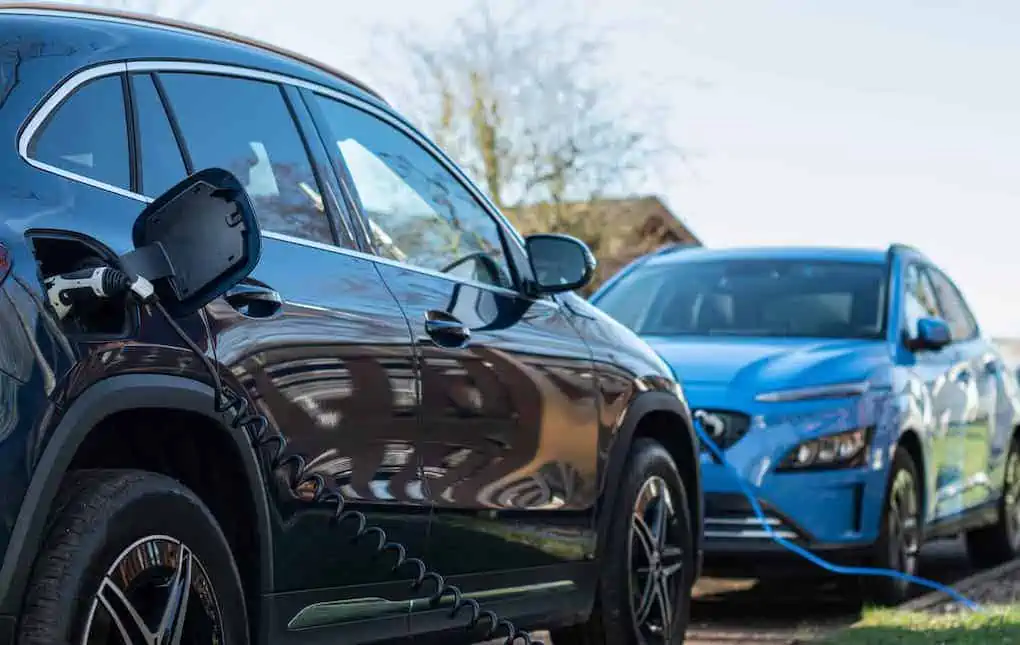 two parked cars plugged into EV on-board charger