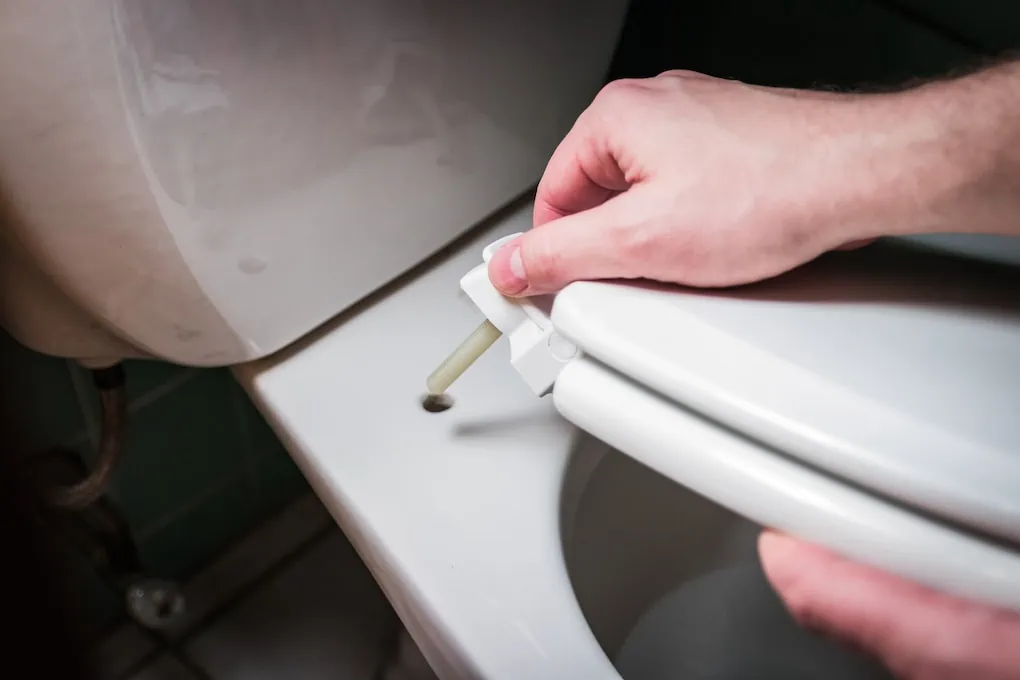 man showing how to install a toilet seat