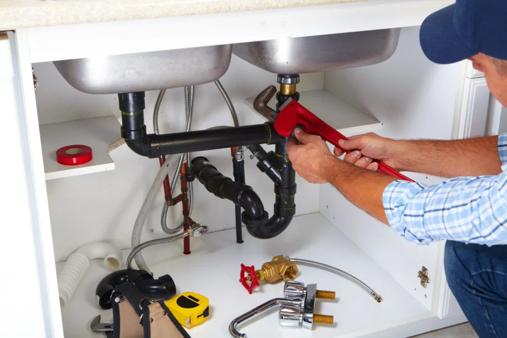 Plumber with Plumbing tools on the kitchen; plumbing basics