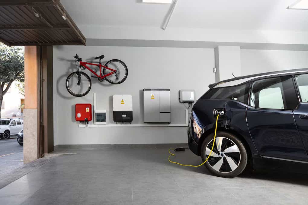 electric vehicle hooked up to solar ev charging station in garage