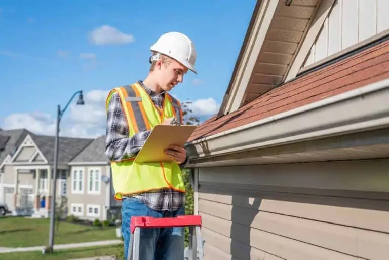 young man on ladder conducting a roof inspection; things that fail a home inspection